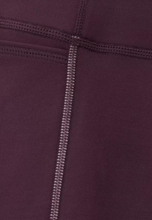 Bordeauxrode sportlegging met een gladde stof, platte naden en een gestructureerd stikselpatroon. Het ontwerp bevat subtiele contrasterende stikselaccenten.