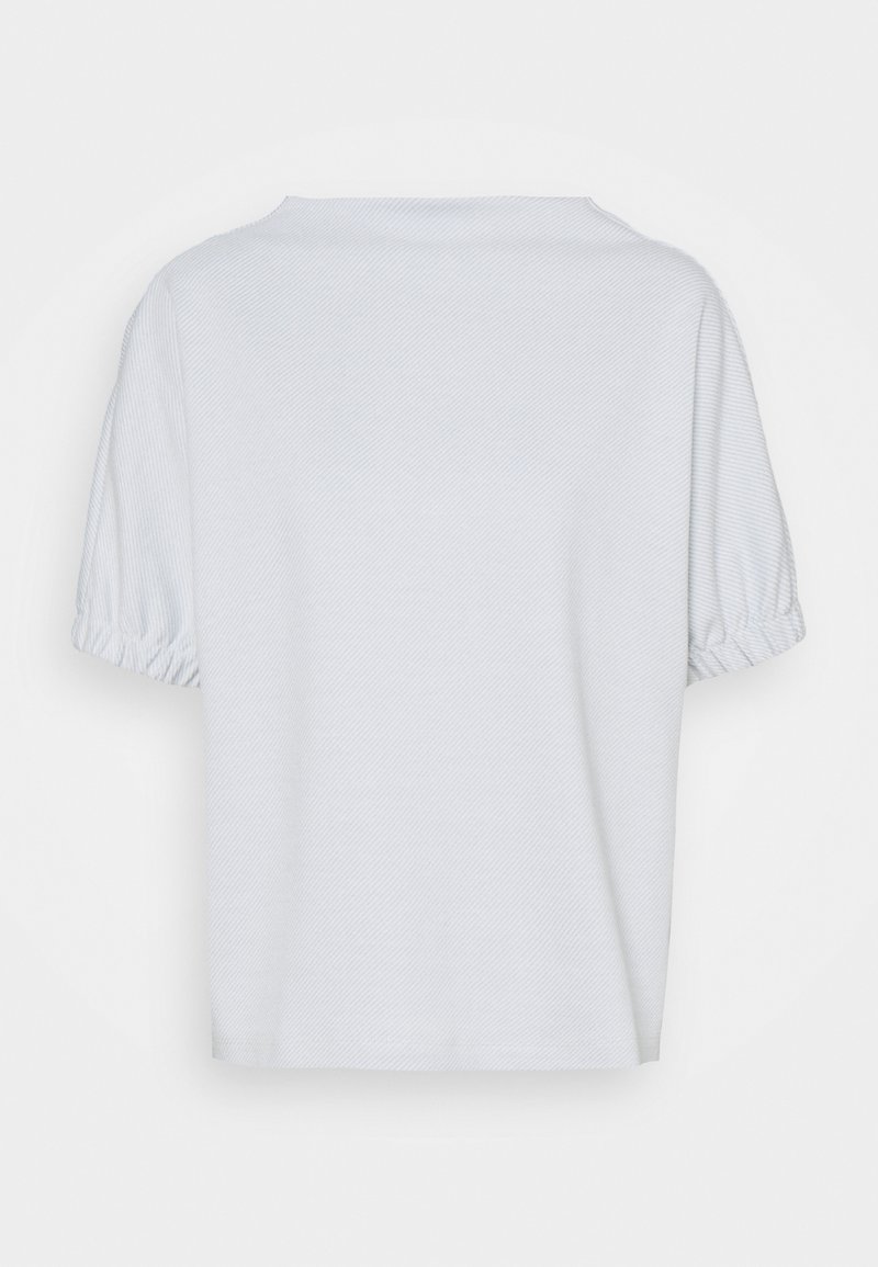 Haut blanc à manches courtes avec manches bouffantes et texture subtile à rayures diagonales, vu de dos sur un fond uni.
