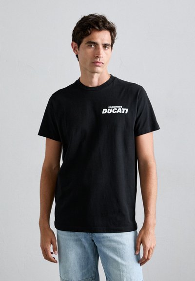 Fekete pamut póló kerek nyakkal, rövid ujjakkal, és fehér "DSQUARED2 DUCATI" felirattal a bal mellrészen.