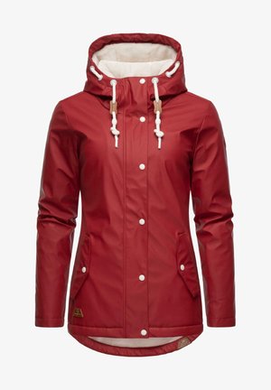 Vörös vízálló dzseki puha bézs bélelt kapucnival, állítható zsinórokkal, fehér gombokkal és két oldalsó zsebbel. Simább, fényes textúra.