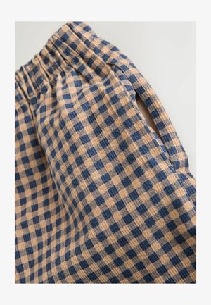 Beige és tengerészkék kockás mintájú anyag, puha textúrával, rugalmas derékkal és oldalsó nyitott részlettel.