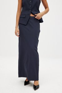 Marineblaue maßgeschneiderte Rock mit gerader Silhouette, leichtem Stoff, seitlichem Schlitz und kombiniert mit einem passenden ärmellosen Blazer.