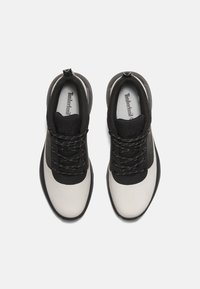 Svarta och vita vandringsskor med en slät, texturerad syntetisk ovandel, rund tå och snörning framtill. Har en vadderad krage och logotypdetaljer.