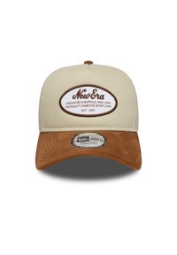 Gorra beige con visera de ante marrón y cierre ajustable tipo snapback. Presenta un parche de logotipo impreso en el frente y tejido texturizado en el cuerpo.