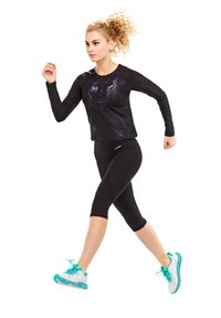 Black long-sleeve top features a panther graphic; paired with black capri leggings and white sneakers with turquoise accents.