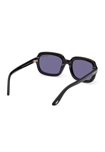 Lunettes de soleil rectangulaires noires avec des montures épaisses et des verres violet foncé, posées sur une surface blanche.