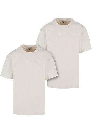 Two light beige cotton t-shirts featuring short sleeves and a crew neckline, with a subtle embroidered logo on the front.