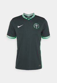 Camiseta de fútbol Nike de color verde oscuro con cuello y puños decorados en verde y blanco, emblema de la Federación Nigeriana de Fútbol en el pecho.