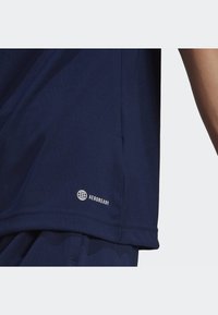 Navy blue athletic shirt made of breathable fabric. Features a logo that reads "AEROREADY" near the hem. Smooth texture with a regular fit.