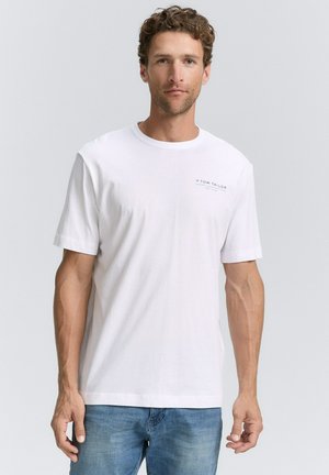 Witte katoen T-shirt met korte mouwen en een ronde halslijn. Heeft een klein gedrukt logo op de borst. Draagt met blauwe jeans.