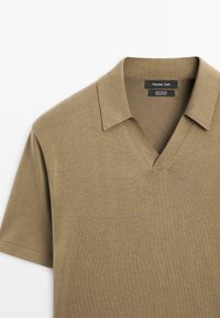 Khaki bawełniana koszulka polo z dekoltem w serek, krótkimi rękawami i gładką tkanką. Zawiera metkę z napisem "Massimo Dutti."