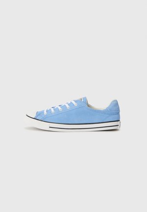 Baskets basses en daim bleu avec lacets blancs et semelle en caoutchouc blanche avec bande noire sur fond uni.