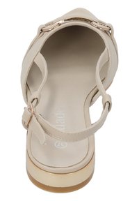 Sandale beige à bout ouvert avec une bride réglable à la cheville, semelle plate et accent en métal sur la bride. Texture lisse sur l'ensemble.
