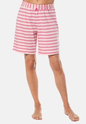 Barfüßige Person, die knielange Shorts mit rosa-weißen, horizontalen Streifen trägt, mit elastischem Bund und einer kleinen rosa Schleife.