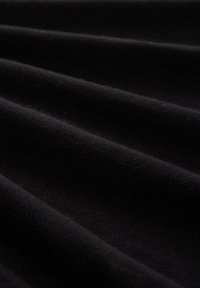 Tissu noir avec une surface texturée et côtelée, présentant des plis doux et un léger éclat. Aucun motif ni détail matériel notable présent.