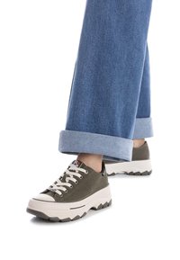 Zapatillas de lona verdes con suela de goma blanca, punta redonda y suela gruesa con relieve. Con cordones beige y un detalle de logo en el lateral.