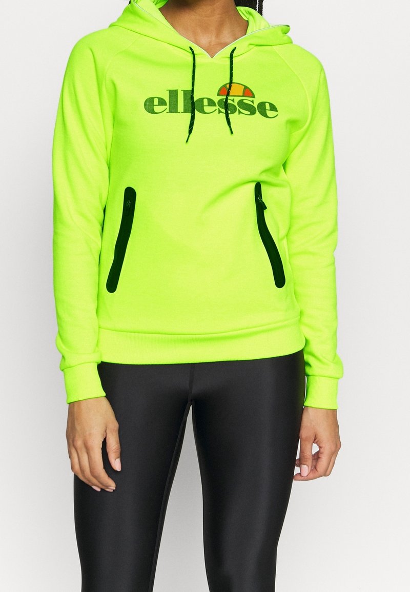 Sudadera con capucha color verde neón, con un logo, que cuenta con bolsillos con cremallera negros y puños acanalados. Fabricada con un tejido suave y elástico.