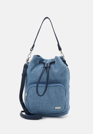Niebieska torba typu bucket z denimu z przednią kieszenią na suwak, granatowym ściągaczem i odpinanym paskiem na ramię na jednolitym tle.