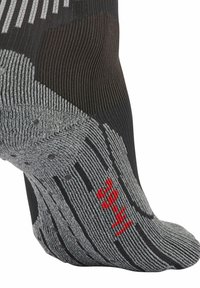 Calcetín texturizado en negro y gris con un patrón a rayas, puntos de agarre en la parte inferior y un acento rojo con el número "35".