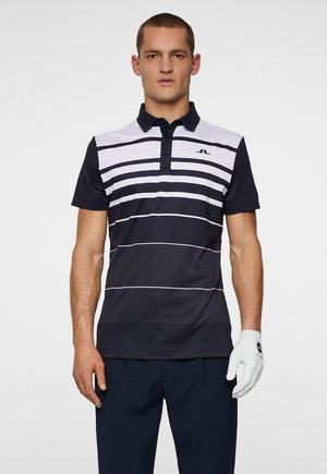 Navy and white striped polo shirt with a collar, short sleeves, and a logo on the chest. Worn with dark trousers and a white golf glove.