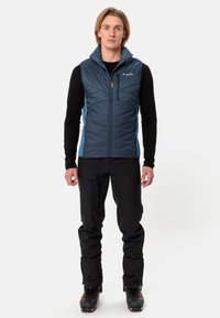 Giubbotto smanicato blu navy con un design trapuntato, colletto alto, pannelli laterali azzurri e una linguetta arancione per la zip.