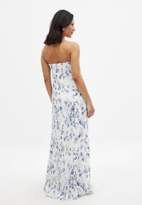Bezramenné maxi šaty s kvetinovým vzorom, biele s modrým a zeleným vzorom, ľahký materiál, skladaná textúra, splývavé až na zem.