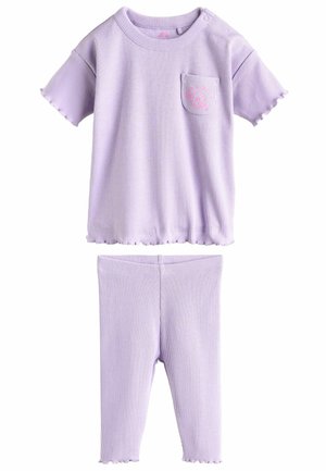 Ensemble deux pièces lilas côtelé comprenant un haut à manches courtes avec une poche et des bords en feston, associé à un legging assorti.