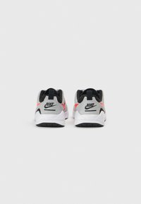 Αθλητικά παπούτσια Nike με γκρι επάνω μέρος, μαύρες λεπτομέρειες και ροζ στοιχείο. Διαθέτουν επένδυση περιμετρικά και λευκή υφή σόλας με μαύρο πέλμα.