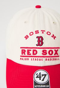 Crvena i bijela bejzbol kapa sa izvezenim natpisom "BOSTON RED SOX" i logom, podesivog dizajna, izrađena od pamučnog materijala.