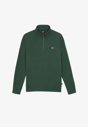 Tmavě zelený fleecový pulovr s vysokým límcem a čtvrtinovým zipem. Obsahuje malou nášivku s logem na hrudi a žebrované manžety a lem.