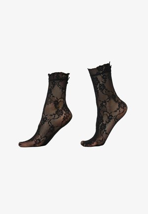 Chaussettes courtes noires transparentes avec motif en dentelle florale et bords supérieurs volantés, présentées sur des formes en forme de pied sur fond blanc.