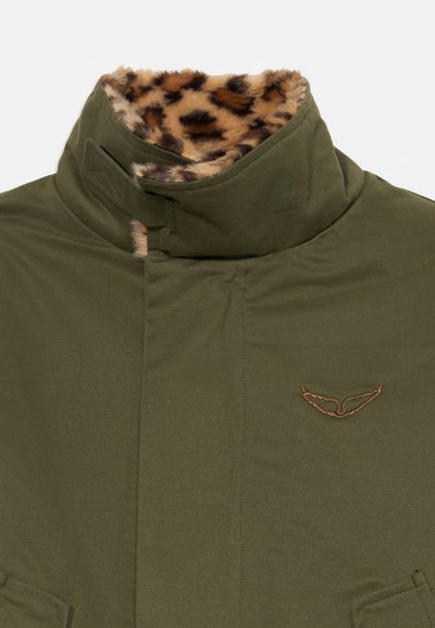 Grøn jakke med høj krave, foret med brunt og sort leopardprint i kunstpels, med et lille broderet brunt vinge-logo på brystet.