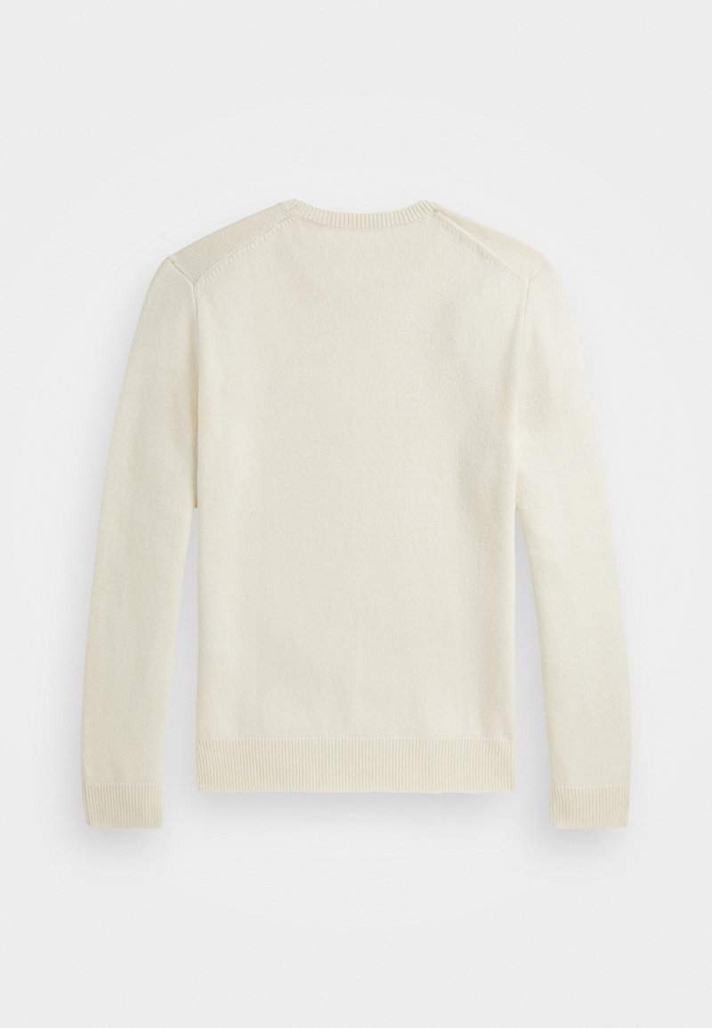 Pull en crème, texture tricotée, poignets et ourlet côtelés, encolure ronde et finitions des épaules sans coutures.