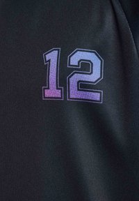 Schwarzer Stoff mit der Zahl "12" in graduierten Blau- und Lilatönen, mit einer strukturierten Oberfläche und kontrastierender Farbgebung.
