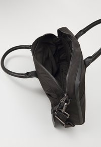 Zwarte leren handtas met stoffen binnenkant, ritssluiting, twee hengsels en gestructureerde accenten. Binnencompartimenten voor organisatie.