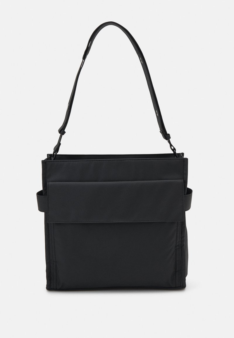 Sort skuldertaske lavet af stof, med en flad frontlomme, justerbar rem og minimalistisk design. Glat tekstur uden mønstre.