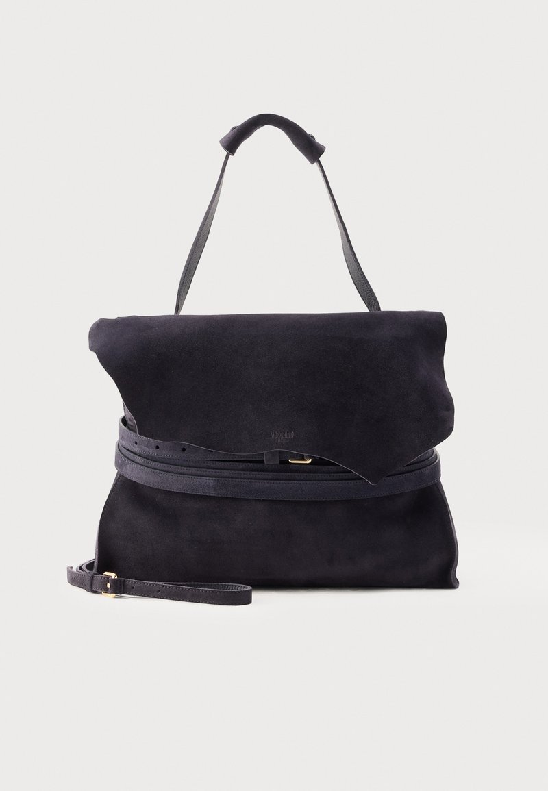 Sac à main en daim noir avec rabat pliant, poignée supérieure, bandoulière fine réglable et détail ceinture autour du milieu sur fond uni.