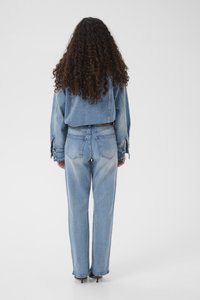 Lys blå denimjakke med cropped snitt og løstsittende bl�å jeans. Har oppbrettede mansjetter og rett ben-design.