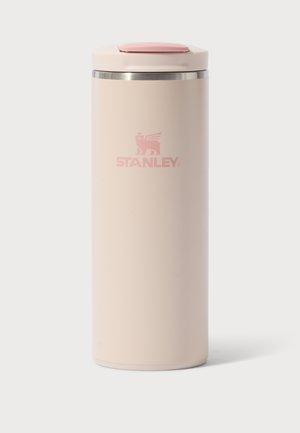 Висока бежова изолирана пътна чаша Stanley с розов капак с люлеещ се отвор и сребърен ръб на бял фон.