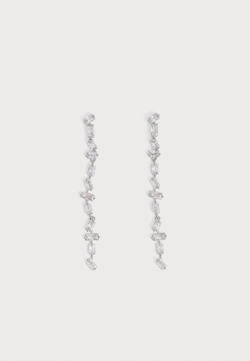 Longues boucles d'oreilles pendantes en argent avec plusieurs cristaux transparents rectangulaires liés verticalement sur un fond gris clair.