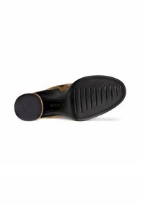 Bruine suède schoen met een zwarte rubberen zool, voorzien van horizontale groeven voor grip en een ronde neus. Glad oppervlak op de bovenkant.