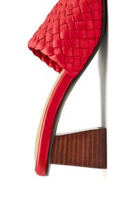 Sandale en cuir tissé rouge à talon bloc en bois, avec une semelle lisse et un nez rond. La texture met en valeur un tissage complexe.