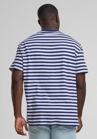 T-shirt rayé bleu marine et blanc, manches courtes, encolure ras du cou, en coton doux, coupe décontractée avec une coupe droite à l'ourlet.