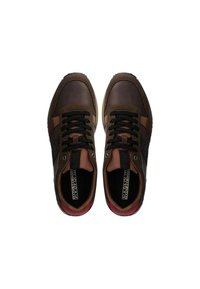 Sneaker in pelle marrone con lacci neri, dotate di una striscia beige a contrasto e accenti rossi sul tallone. Suola in gomma testurizzata.