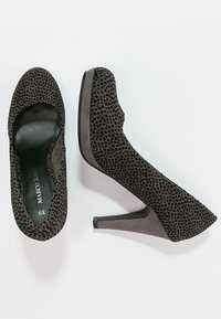 Chaussures à talons hauts en suédine grise avec un motif texturé à pois, bout arrondi et talon fin. L'intérieur présente une doublure noire lisse.