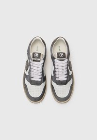 S sneakers com um cabedal em couro preto e branco, bico perfurado, detalhes cinzas e uma sola de borracha com um design durável e atacadores brancos.