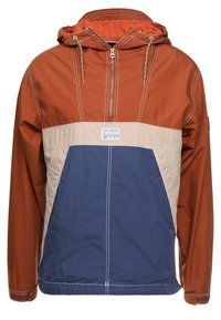 Kleurgeblokte anorakjas met bruine, beige en marineblauwe panelen, voorzien van een verstelbare capuchon en een ritssluiting aan de voorkant, gemaakt van lichtgewicht stof.