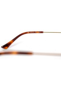 Hnědé želvovinové sluneční brýle s elegantním designem a zlatě tónovanými kovovými stranami. Obsahuje velikostní označení: 63-16-150 a ochranu proti UV záření kategorie 3.