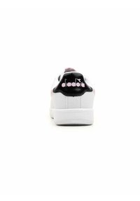 Sneaker bianca con superficie testurizzata, dotata di un tallone nero con il logo "diadora" rosa e sottili accenti rosa sui lati.