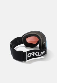 Skidglasögon med ett svart elastiskt band, vitt logotyp, svart skumvaddering och dubbla linser; en lins är tonad i rosa, den andra är blå.